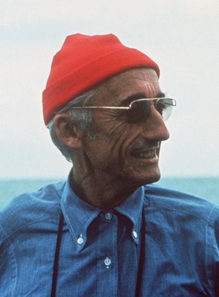 Jaques Cousteau with a red beanie and blue denim shirt.