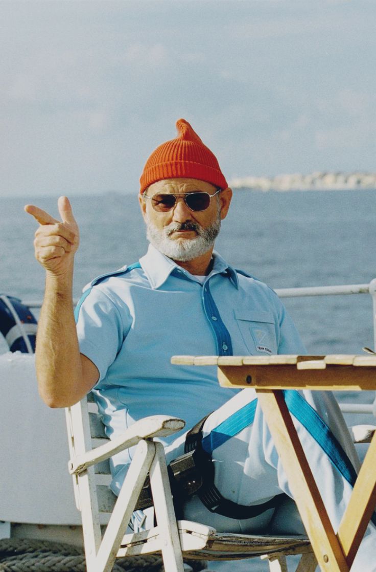 Steve Zissou points with his pointy red beanie