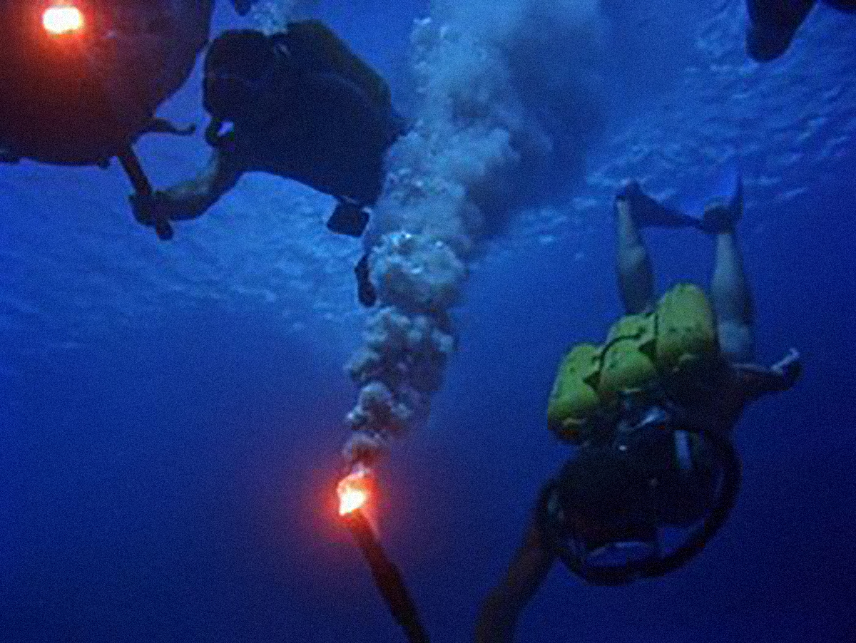 Jacques Cousteau diving with flares.